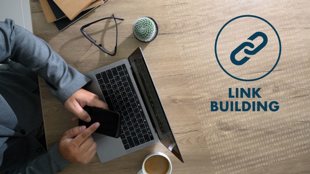 A person working on a laptop with a link building symbol, highlighting the importance of digital strategies for building a website’s authority with quality link building.